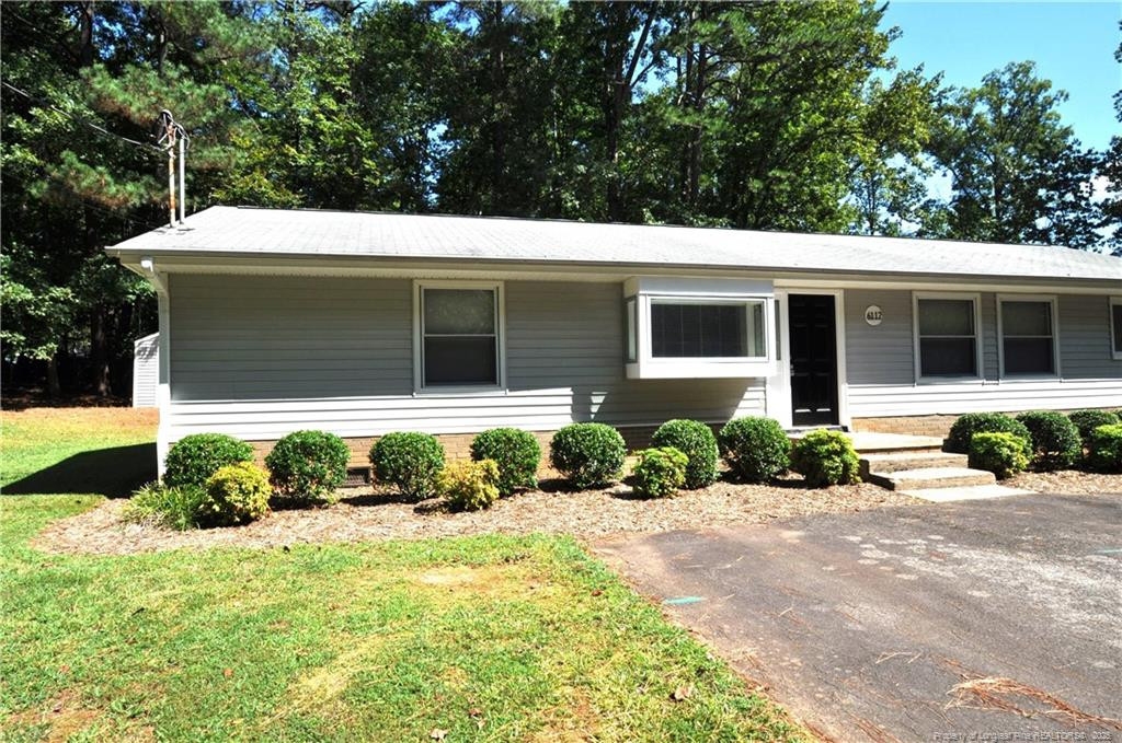 a front view of a house with a yard and potted plants