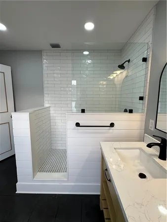 a bathroom with a sink a toilet a mirror and shower