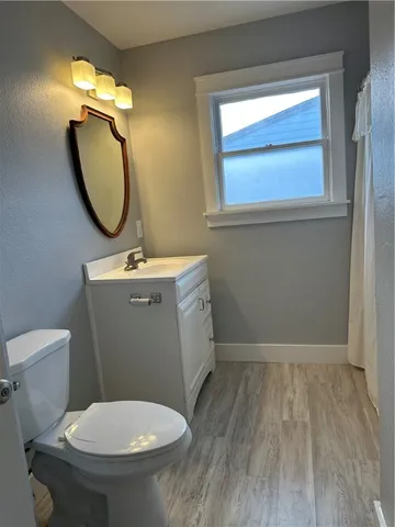 a bathroom with a toilet a sink and mirror