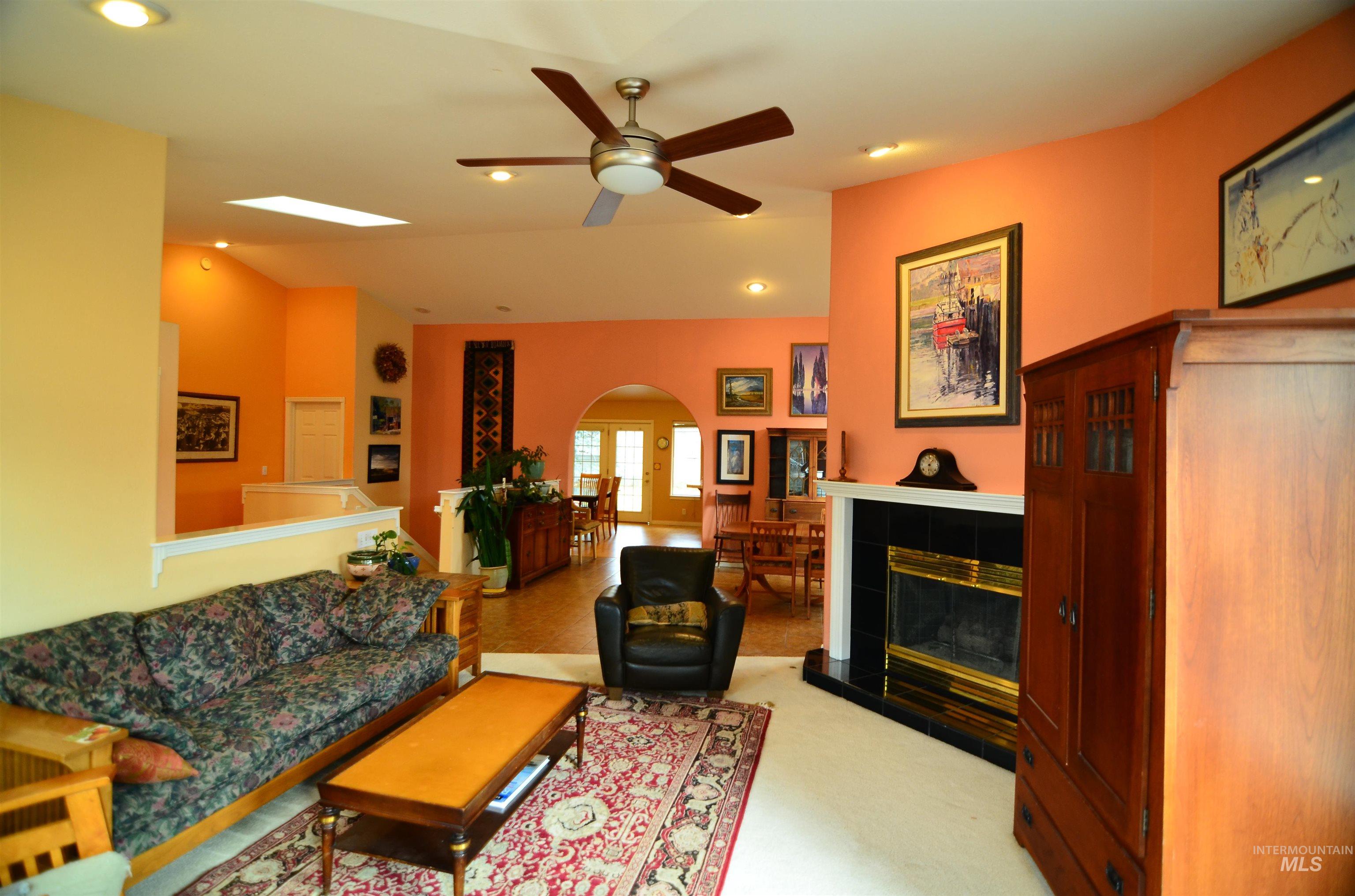 690 Granite Way Boise, ID 83712 - Photo 25 of 30 Living area featuring arched walkways, a fireplace, vaulted ceiling, recessed lighting, and light colored carpet
