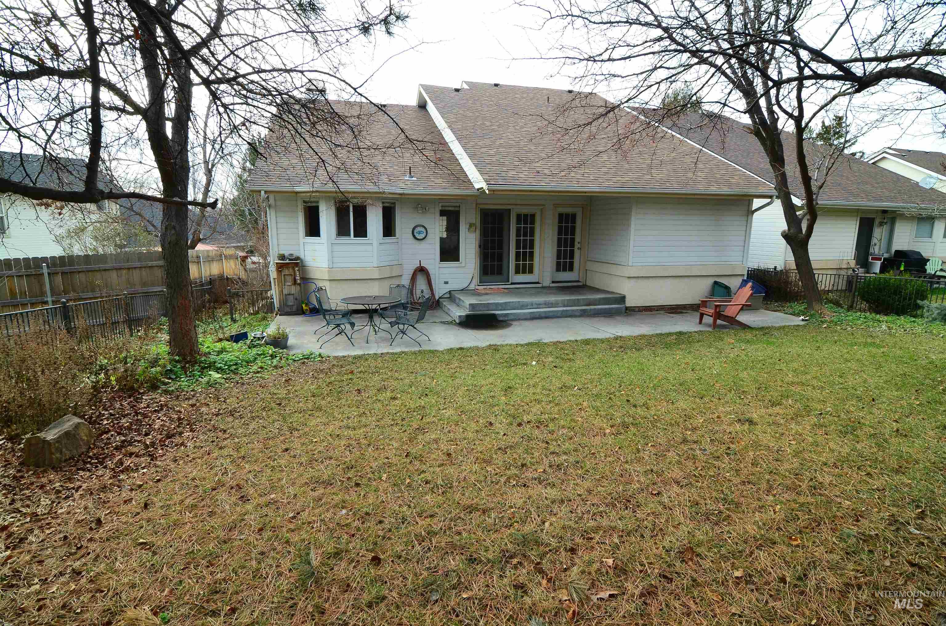 690 Granite Way Boise, ID 83712 - Photo 30 of 30 Back of property featuring a patio, a fenced backyard, and roof with shingles