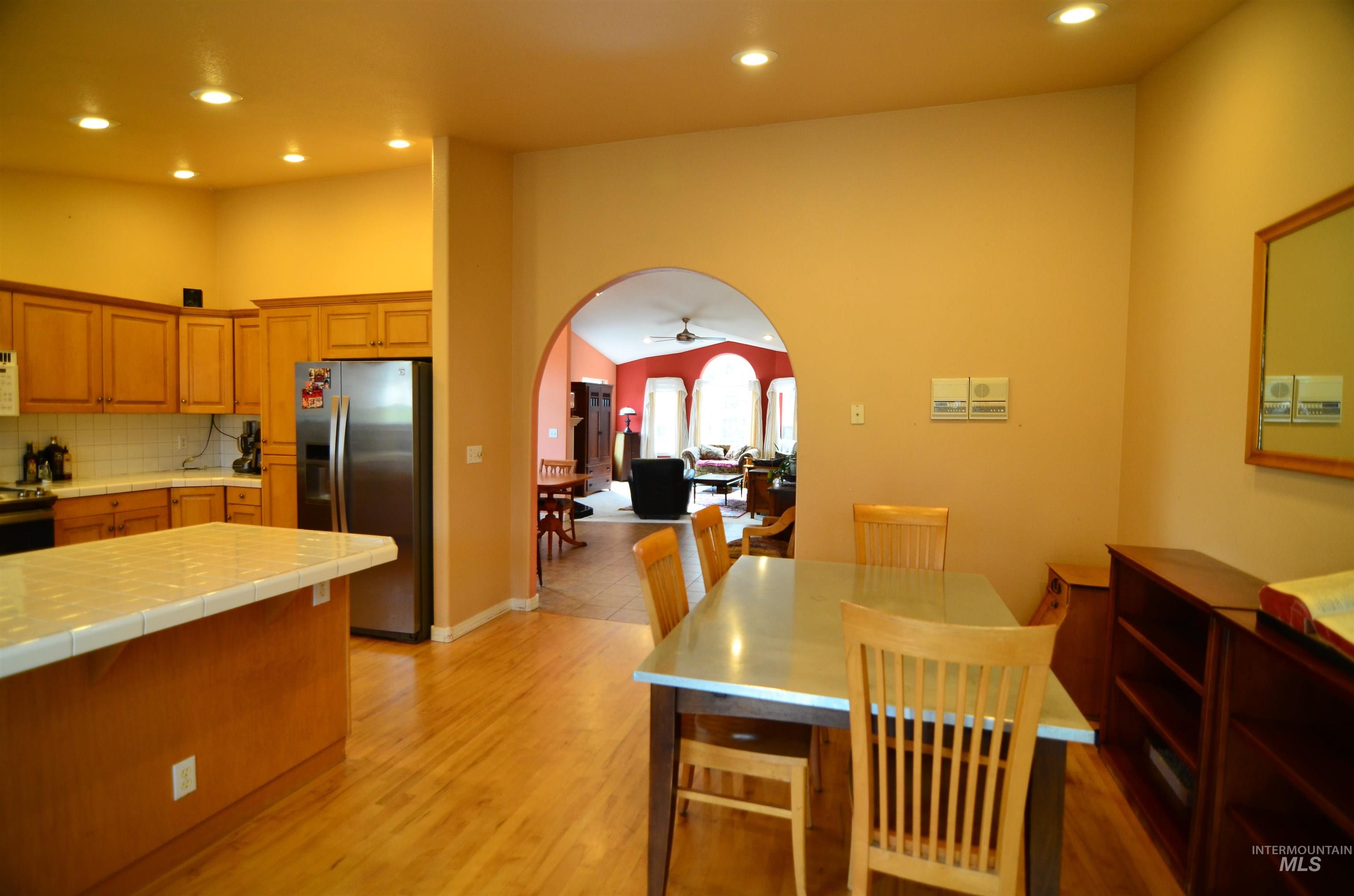 690 Granite Way Boise, ID 83712 - Photo 6 of 30 Kitchen featuring tile counters, appliances with stainless steel finishes, arched walkways, recessed lighting, and a ceiling fan