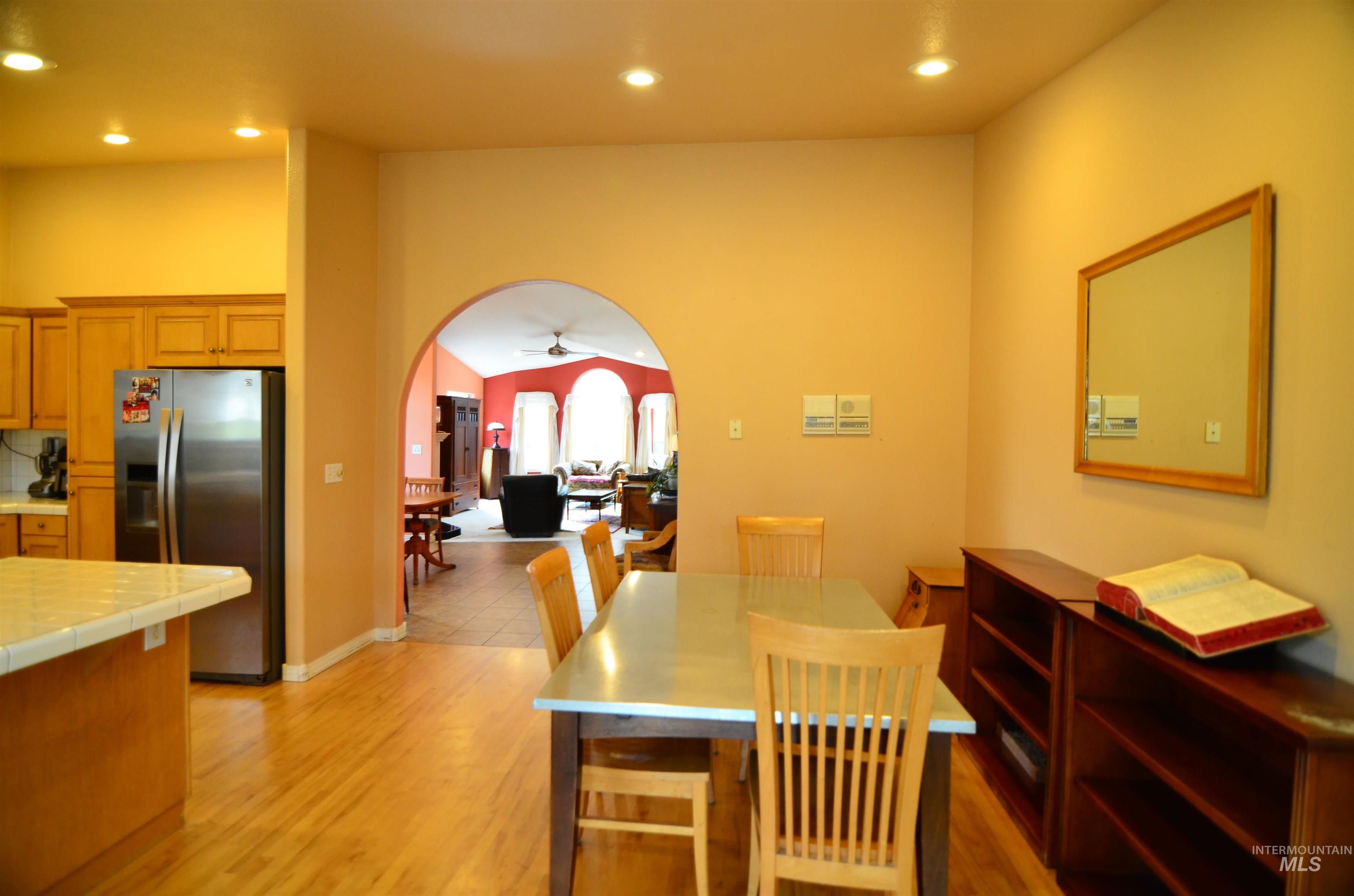 690 Granite Way Boise, ID 83712 - Photo 10 of 30 Dining area with arched walkways, ceiling fan, recessed lighting, and light wood-style floors