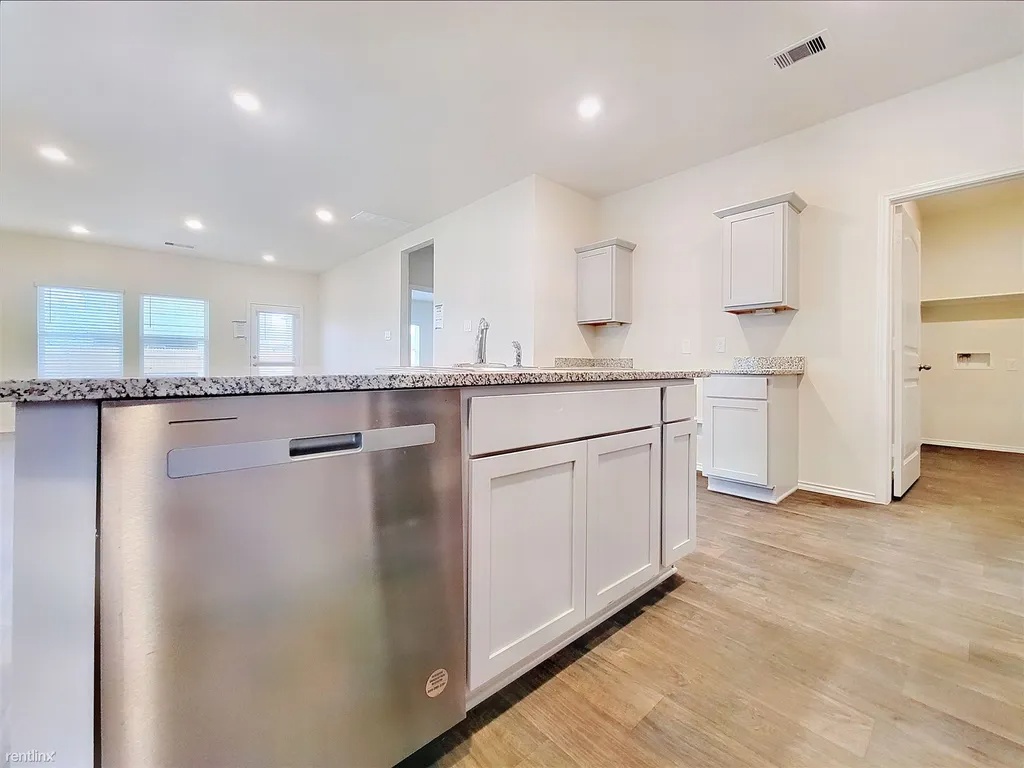 419 Sickle Loop Kyle, TX 78640 - Photo 7 of 35 A well-appointed kitchen features a large island and ample cabinetry, ready for culinary endeavors.