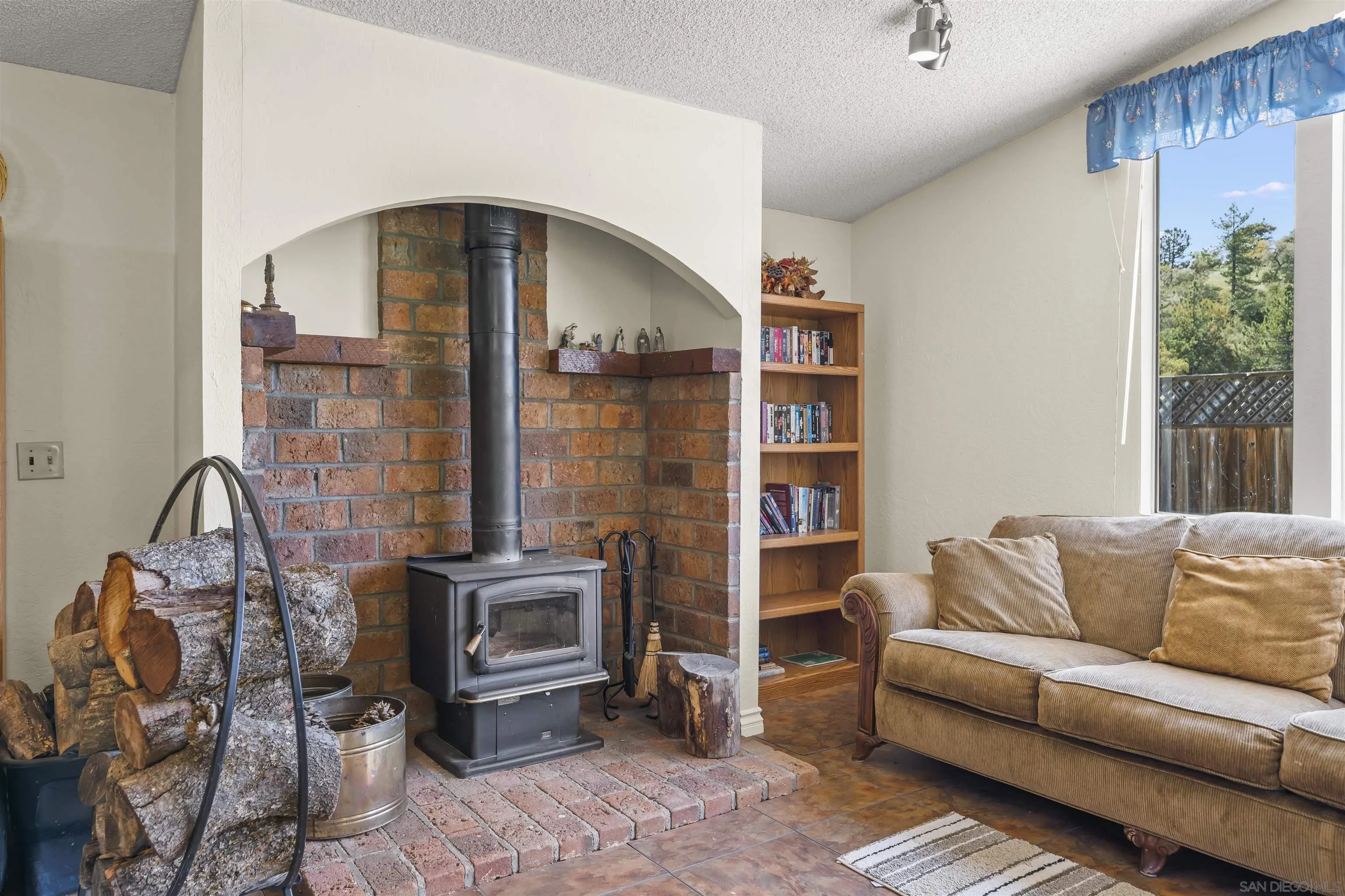 2464 Wynola Road Julian, CA 92036 - Photo 33 of 50 a living room with furniture a lamp and a fireplace