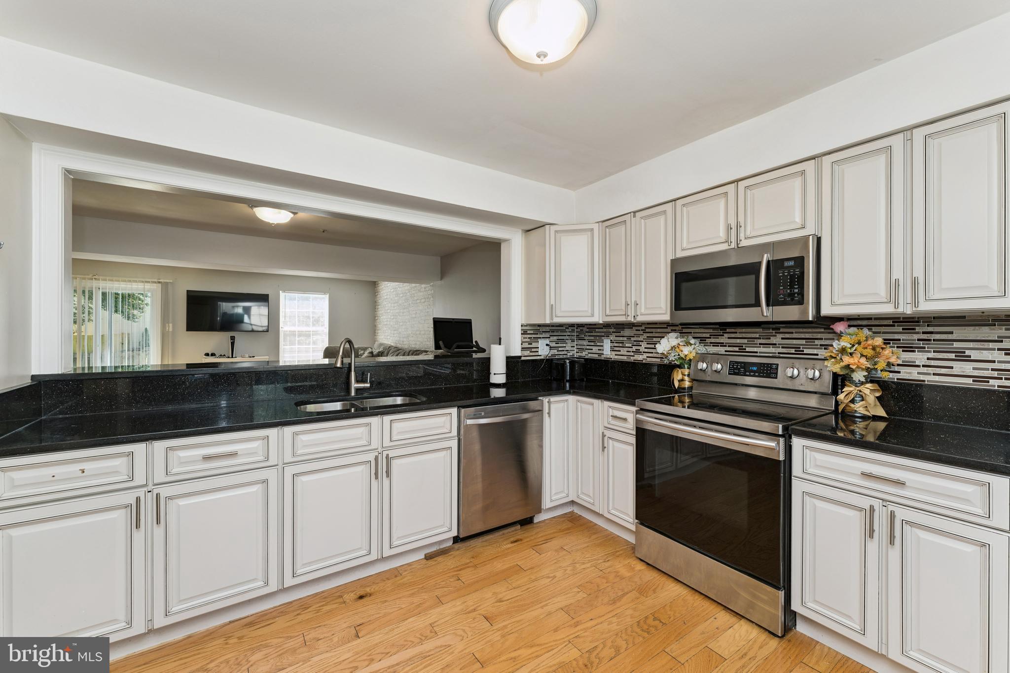 8697 Ritchboro Road District Heights, MD 20747 - Photo 7 of 25 a kitchen with granite countertop a sink and white cabinets