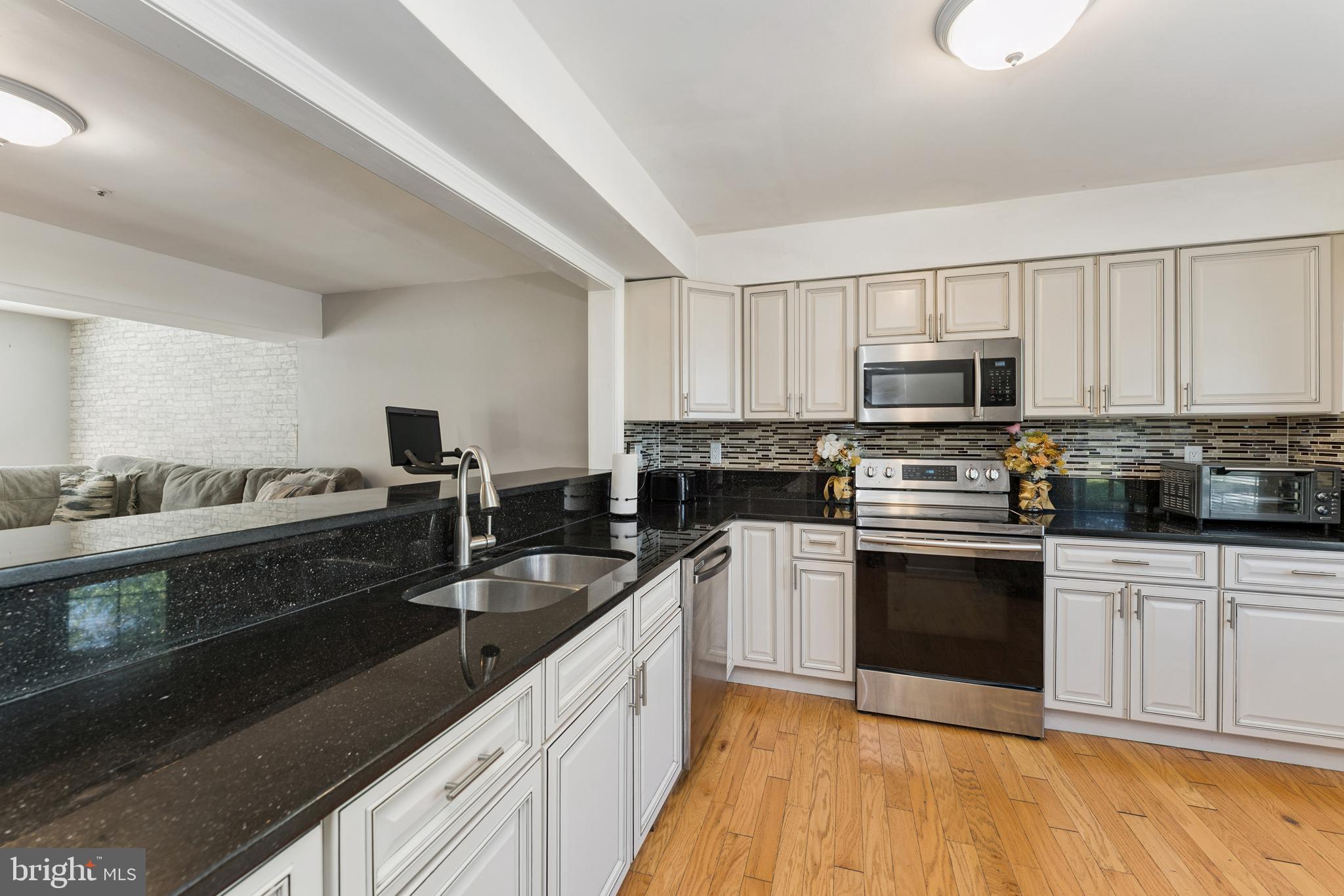 8697 Ritchboro Road District Heights, MD 20747 - Photo 8 of 25 a large kitchen with a sink and stainless steel appliances