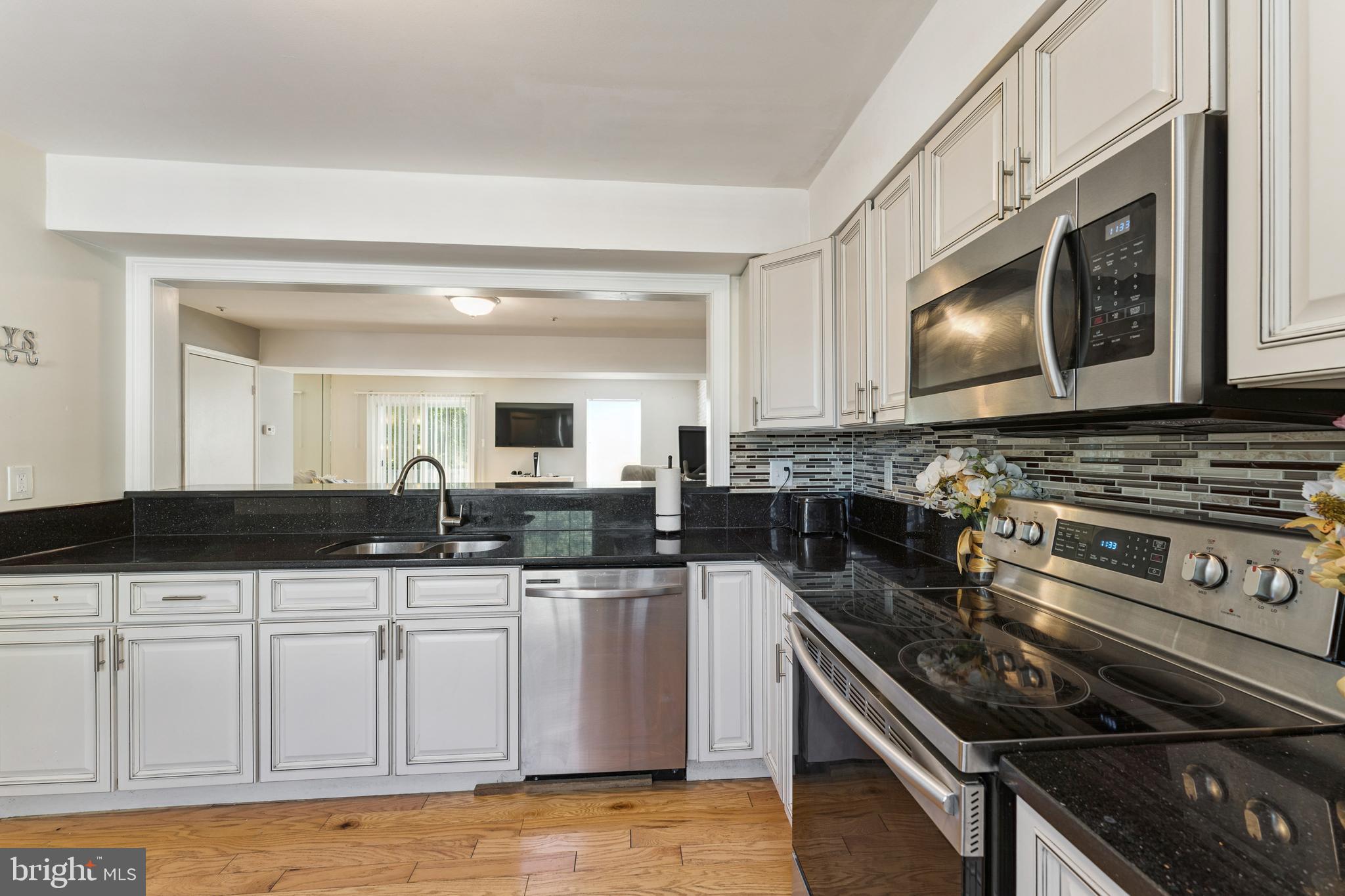 8697 Ritchboro Road District Heights, MD 20747 - Photo 9 of 25 a kitchen with granite countertop a sink and a stove top oven