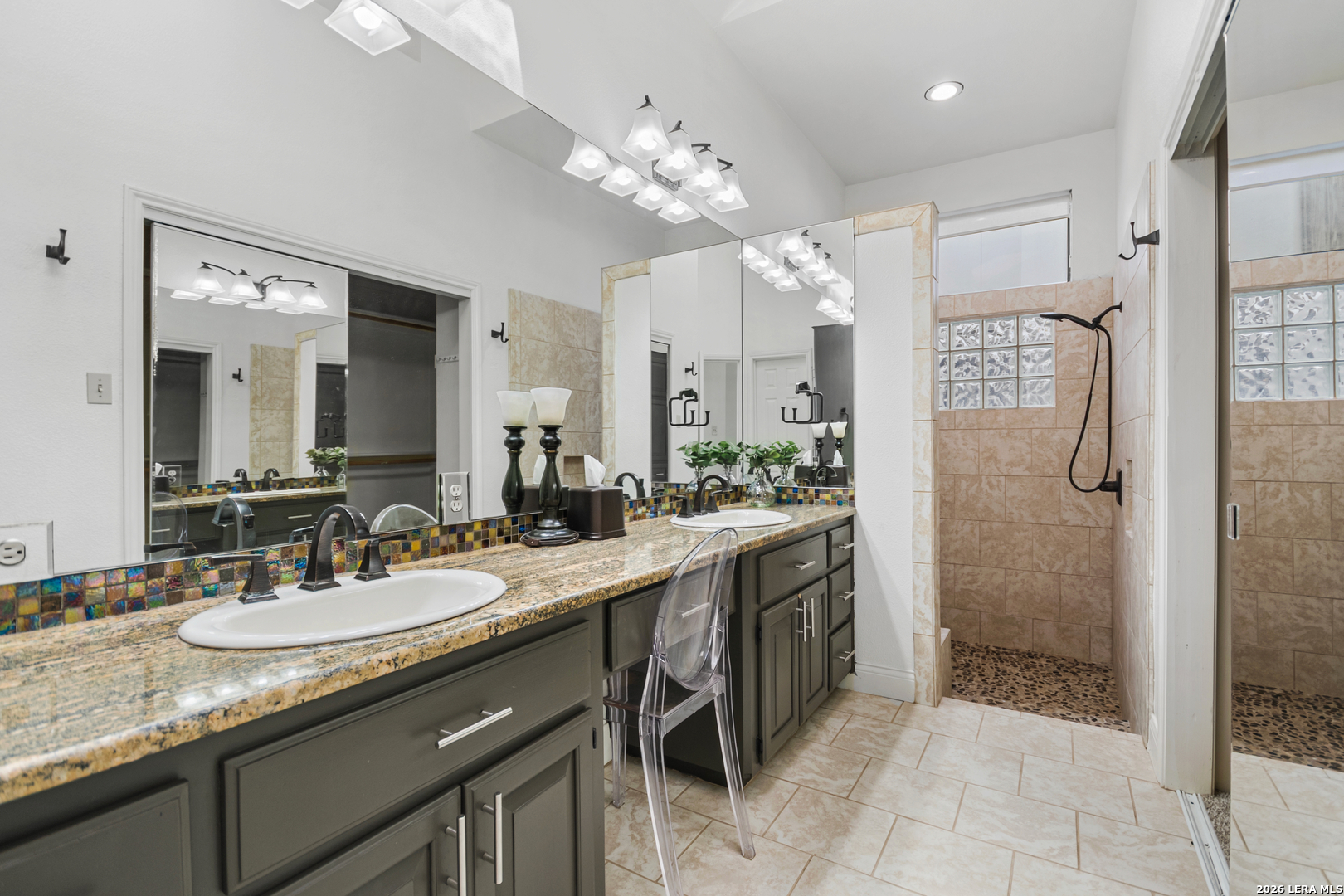 29439 Summit Ridge Drive Fair Oaks Ranch, TX 78015 - Photo 16 of 34 a spacious bathroom with a granite countertop sink a mirror and a shower
