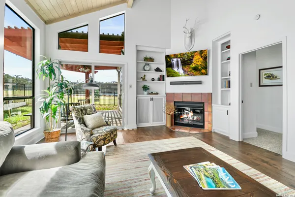 a living room with furniture a rug wooden floor and a fireplace