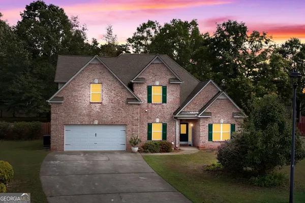 a front view of a house with yard and green space
