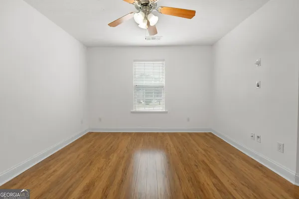 a view of a room with wooden floor and fan