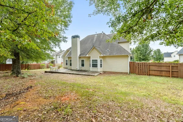 a view of a house with a yard and large tree