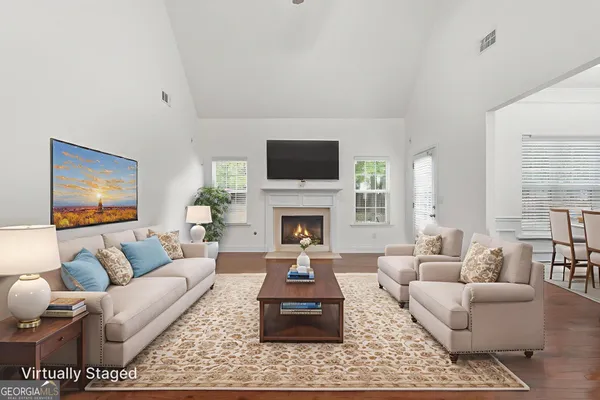 a living room with furniture a flat screen tv and a fireplace