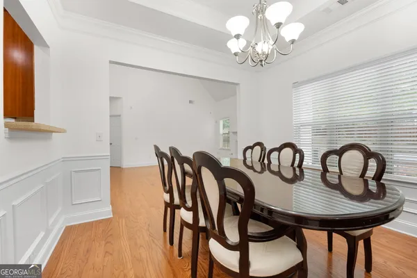 a view of a dining room with furniture a chandelier and wooden floor