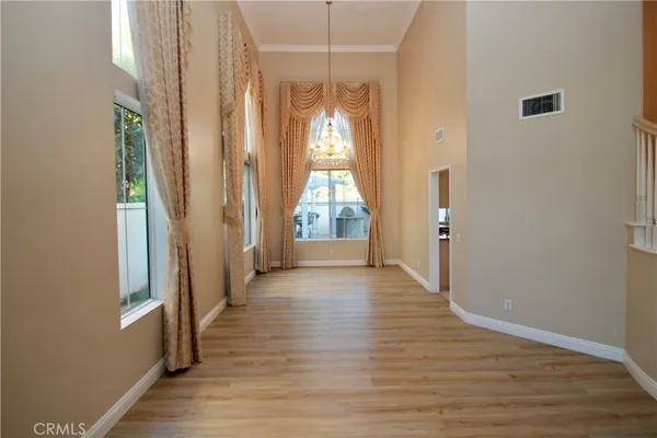 a view of a room with wooden floor door and windows