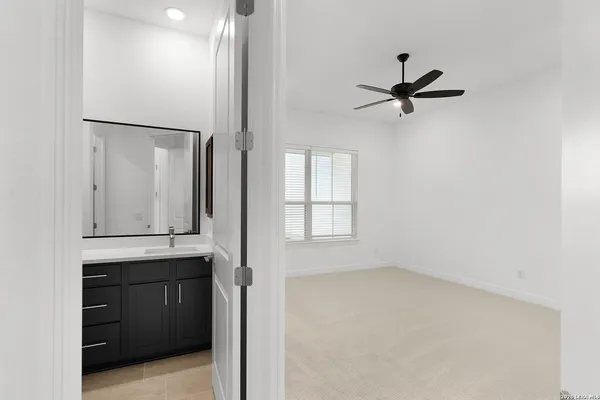 an empty room with a window and a fan