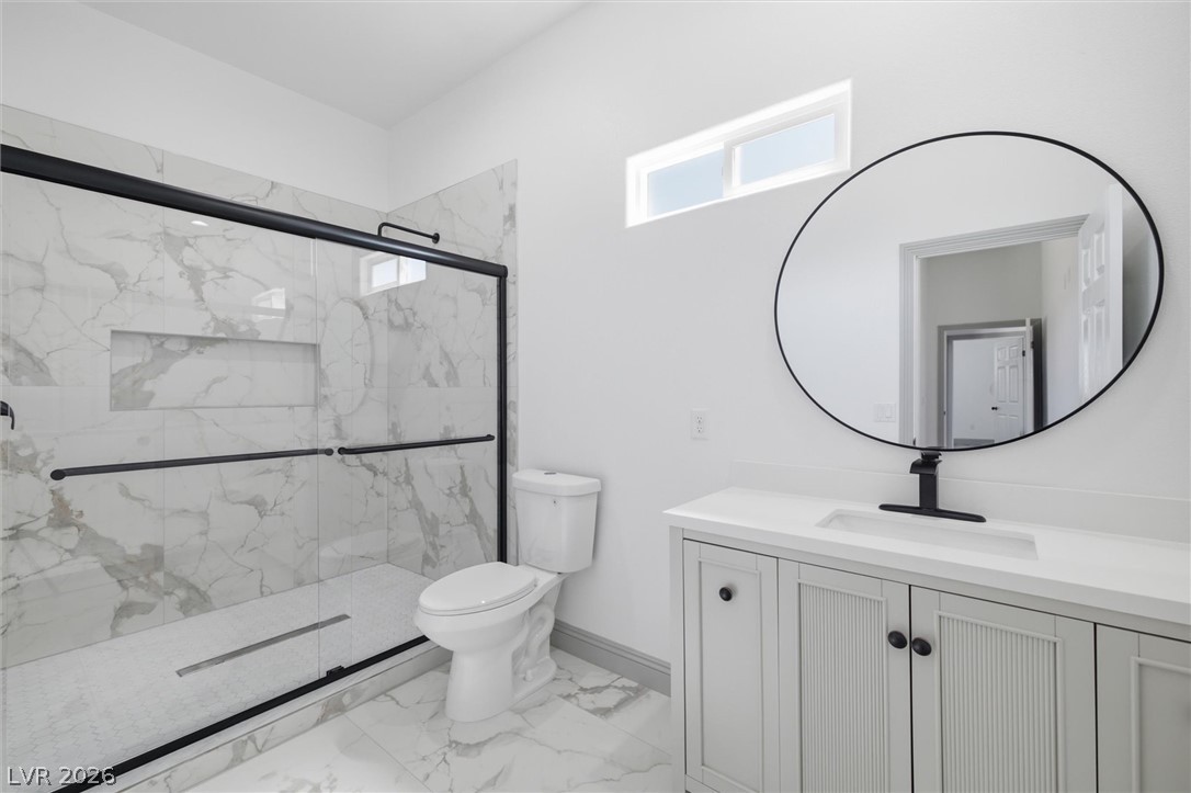 1061 Factory Road Pahrump, NV 89048 - Photo 23 of 41 A well-appointed bathroom with marble-patterned tile, modern shower enclosure, and ample vanity space awaits.