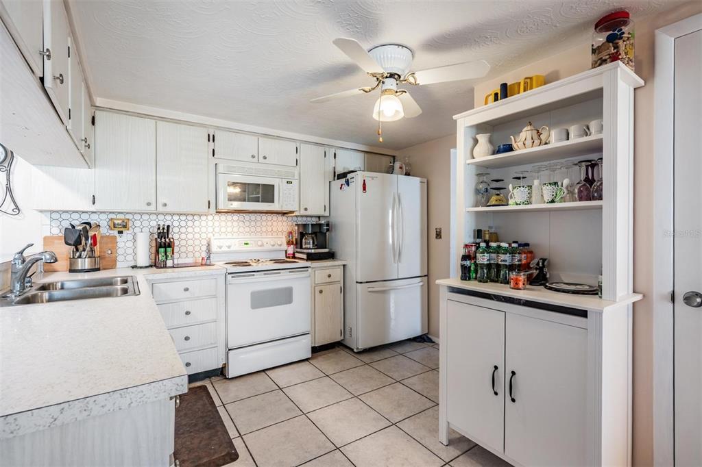 3608 Umber Road Holiday, FL 34691 - Photo 7 of 20 a kitchen with white cabinets and white appliances