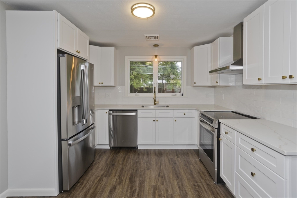 77 Drexel Street Springfield, MA 01104 - Photo 13 of 40 a kitchen with a sink wooden floor and stainless steel appliances