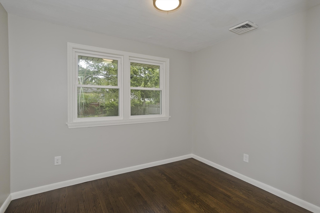 77 Drexel Street Springfield, MA 01104 - Photo 23 of 40 an empty room with wooden floor and windows