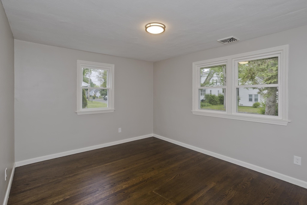 77 Drexel Street Springfield, MA 01104 - Photo 27 of 40 a view of an empty room with wooden floor and a window