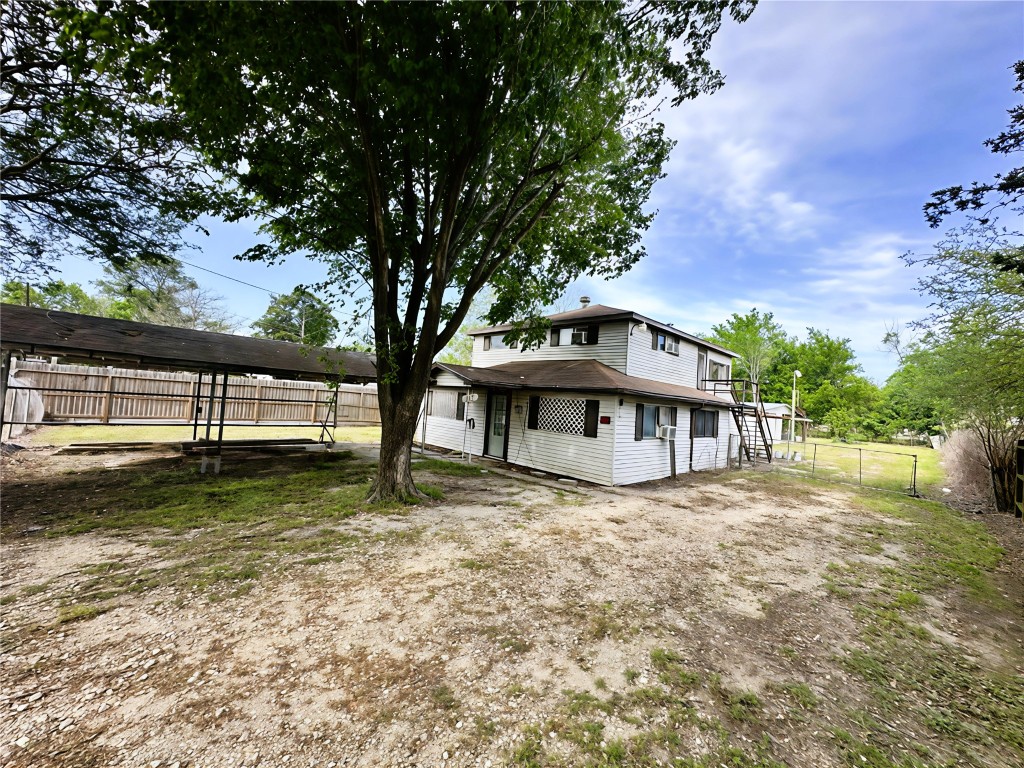 207 South 5th Street Highlands, TX 77562 - Photo 11 of 15 a view of a house with a large tree and a yard with green space