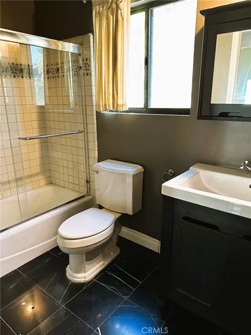 a bathroom with a sink toilet a mirror and shower