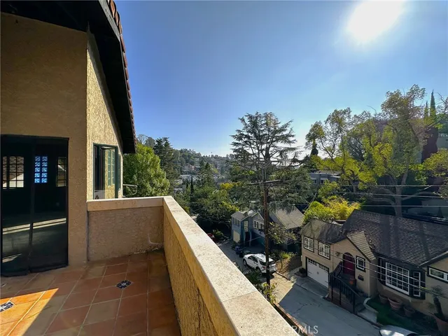 a view of a balcony with chairs and iron stairs