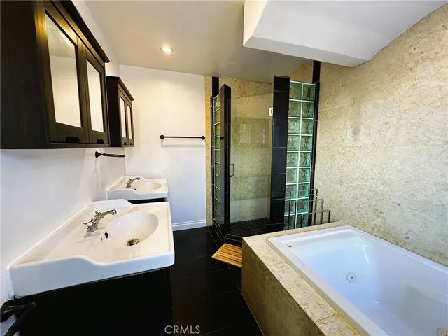 a bathroom with a tub sink and mirror