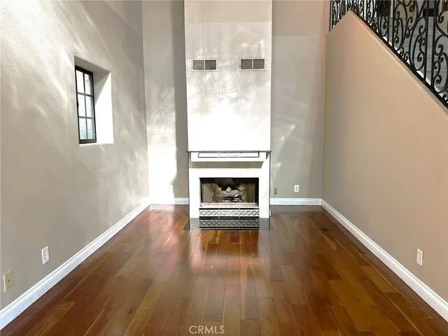a view of a livingroom with wooden floor and a fireplace