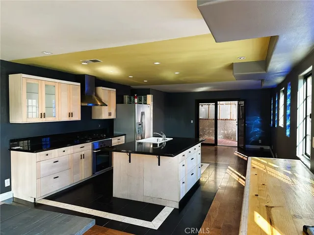 a kitchen with stainless steel appliances kitchen island granite countertop a sink and cabinets