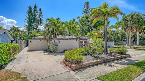 a view of a house with a yard and potted plants