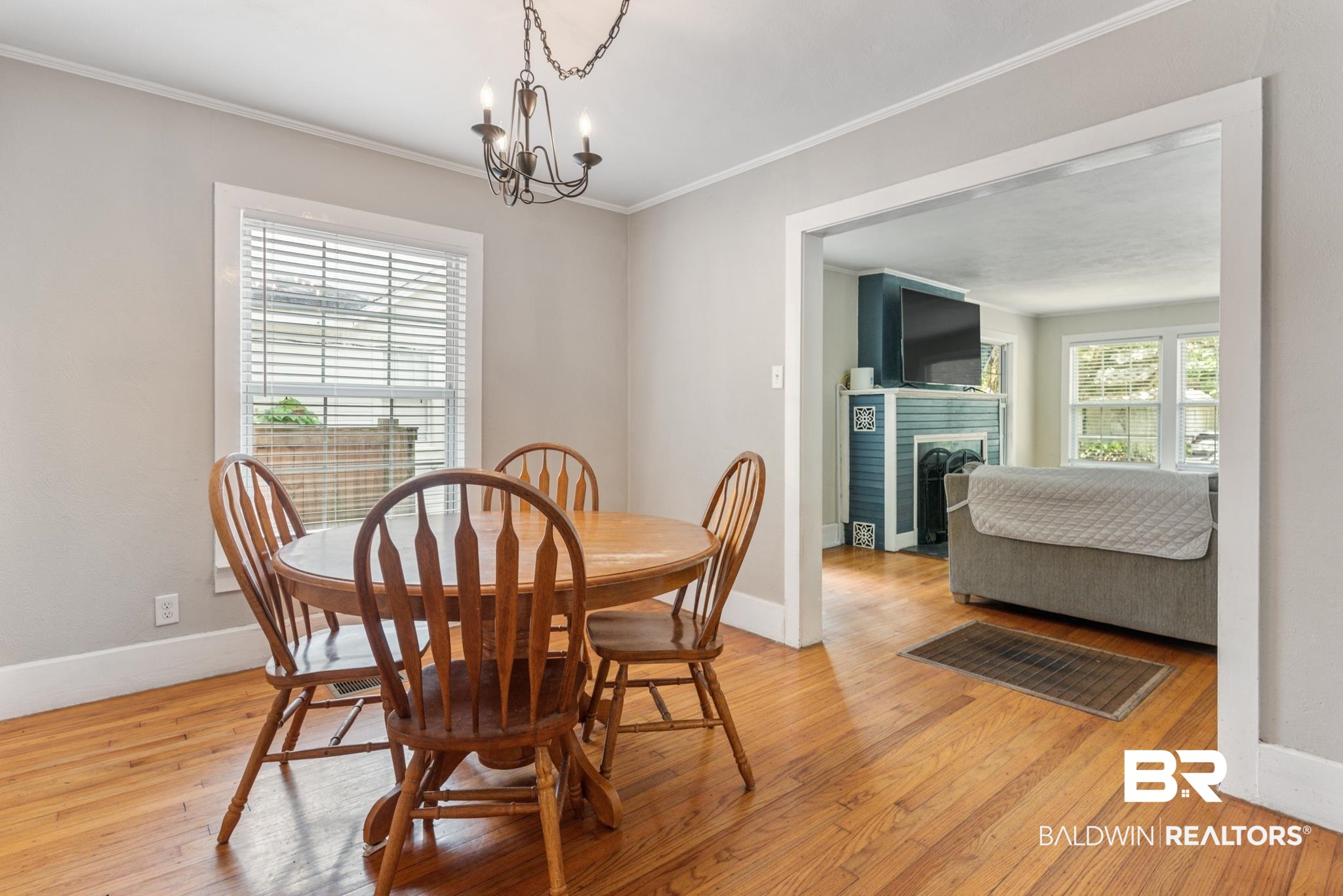 114 Crenshaw Street Mobile, AL 36606 - Photo 15 of 49 Dining area with a notable chandelier, crown molding, a wealth of natural light, and light wood-type flooring