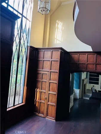 a view of an empty room with wooden floor and windows