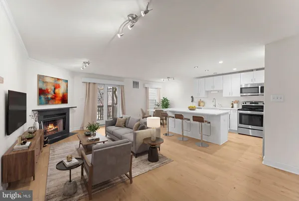 a living room with furniture a flat screen tv and a fireplace