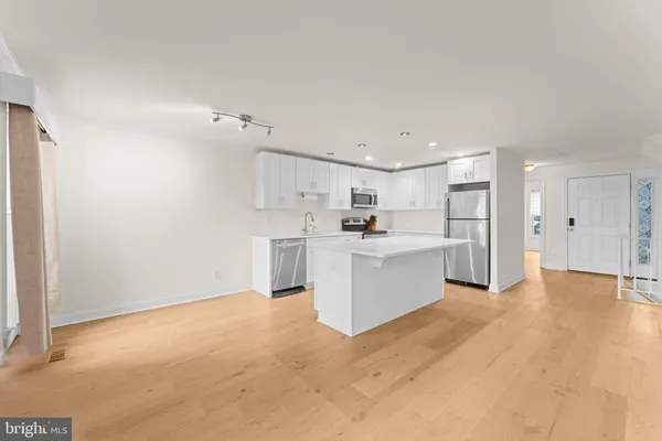 a kitchen with stainless steel appliances a refrigerator sink and cabinets