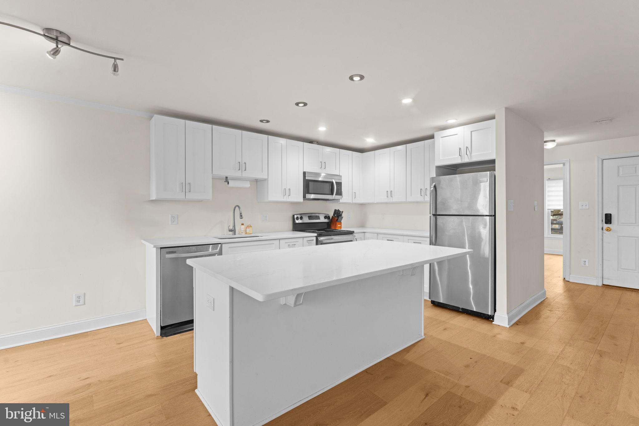2105 North Rolfe Street, Unit A Arlington, VA 22209 - Photo 12 of 56 a kitchen with stainless steel appliances a refrigerator sink and cabinets