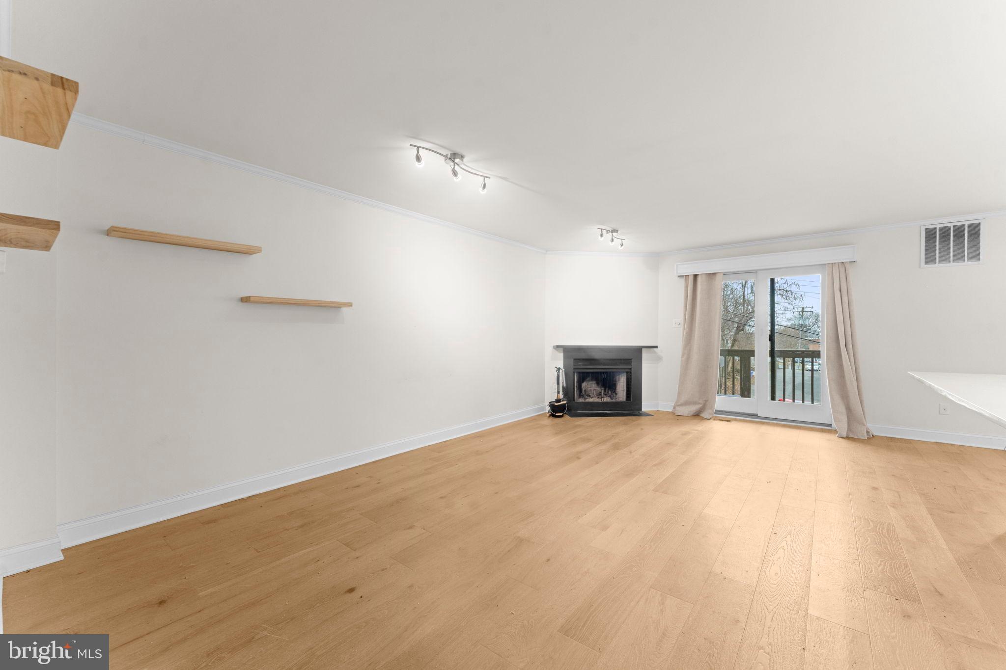 2105 North Rolfe Street, Unit A Arlington, VA 22209 - Photo 6 of 56 a view of an empty room with a fireplace and a window