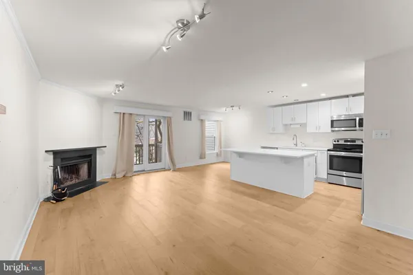 a kitchen with a sink a refrigerator and a stove top oven with white cabinets