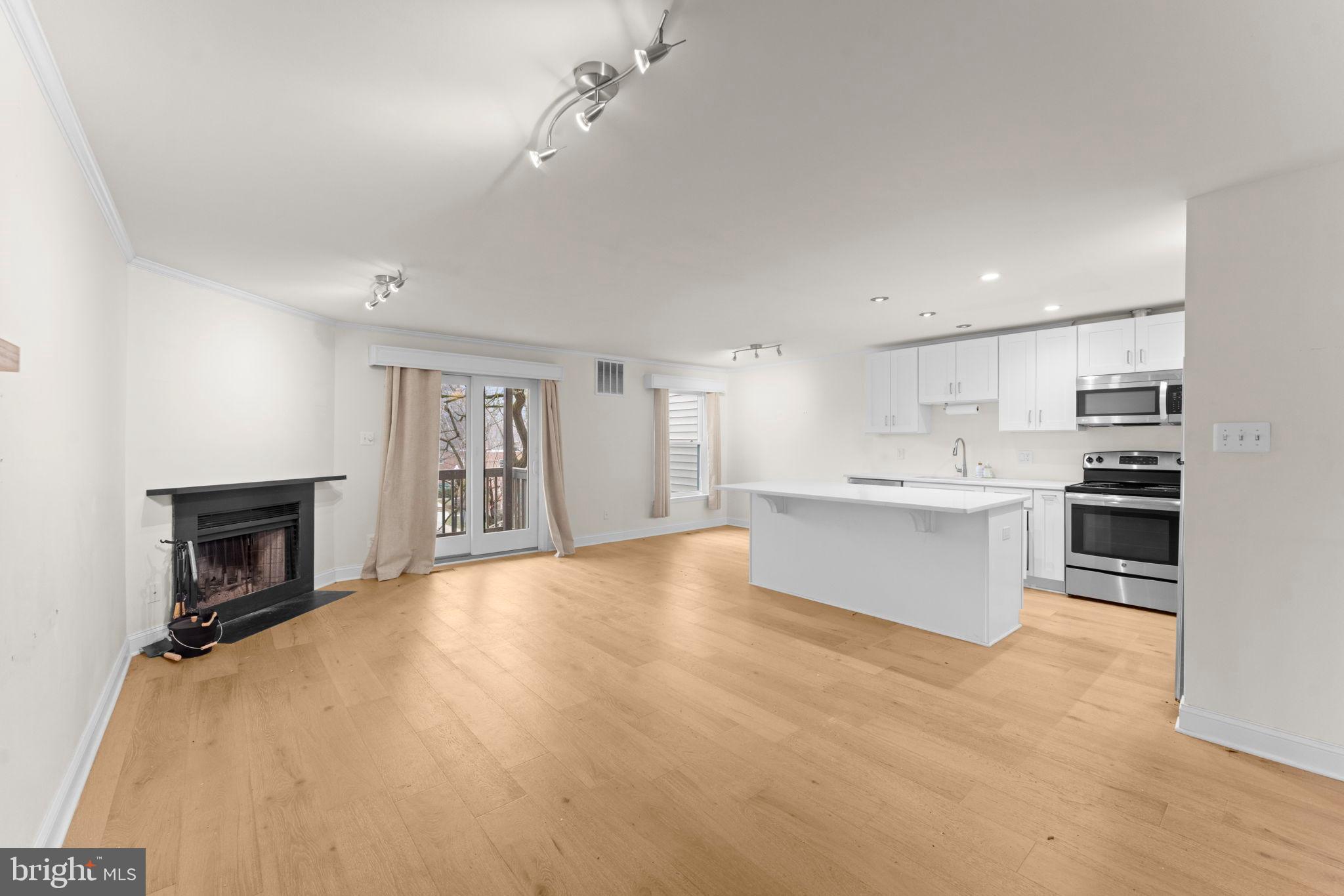 2105 North Rolfe Street, Unit A Arlington, VA 22209 - Photo 7 of 56 a large white kitchen with kitchen island a sink a stove and white cabinets