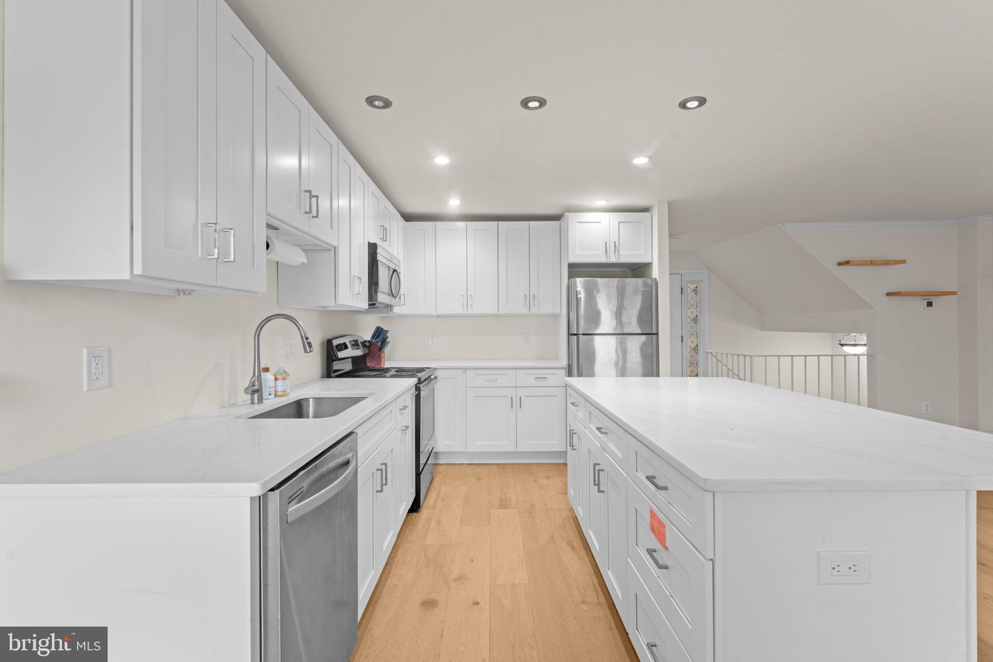 2105 North Rolfe Street, Unit A Arlington, VA 22209 - Photo 9 of 56 a kitchen with white cabinets appliances and sink