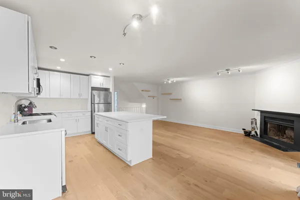 a view of a kitchen with refrigerator and white cabinets