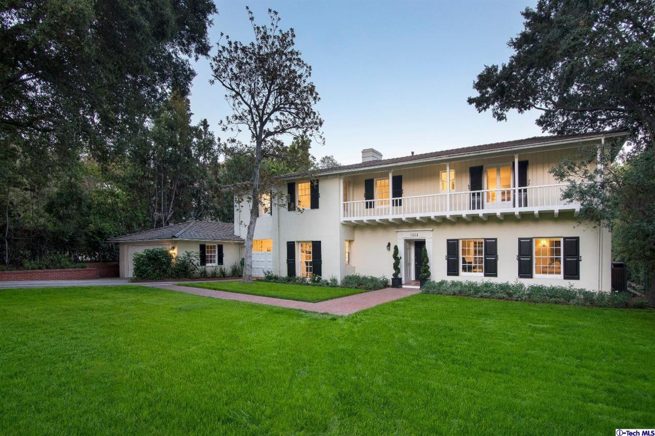 a view of a house with a big yard and large trees
