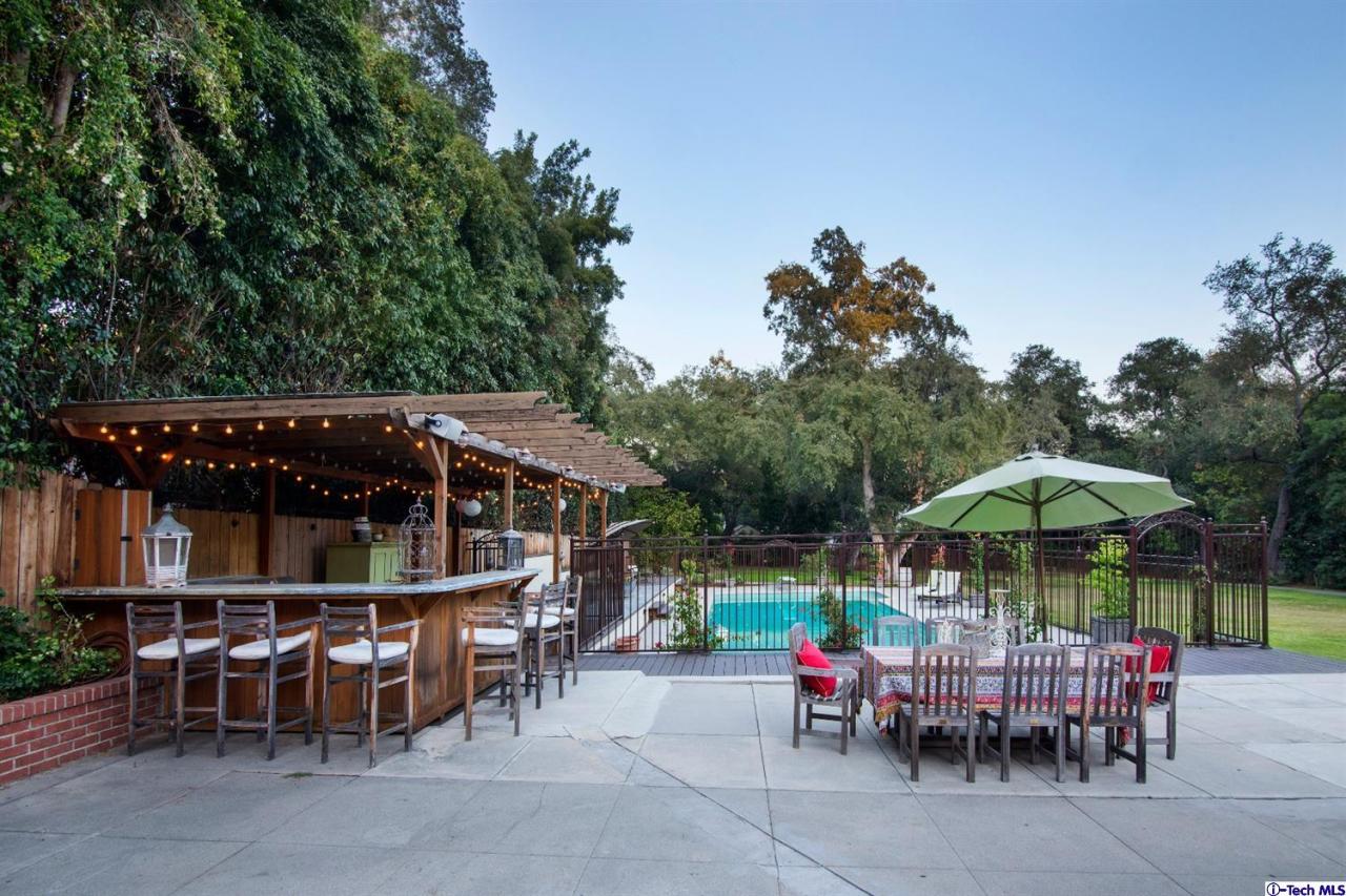 1814 Midlothian Drive Altadena, CA 91001 - Photo 41 of 42 a view of dining area with chairs and table under an umbrella