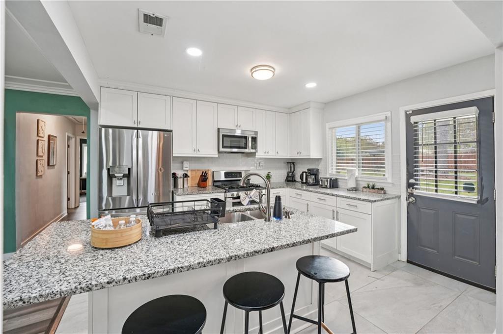 2659 Glenvalley Drive Decatur, GA 30032 - Photo 16 of 59 a kitchen with granite countertop stainless steel appliances a sink a stove a refrigerator cabinets and dining table