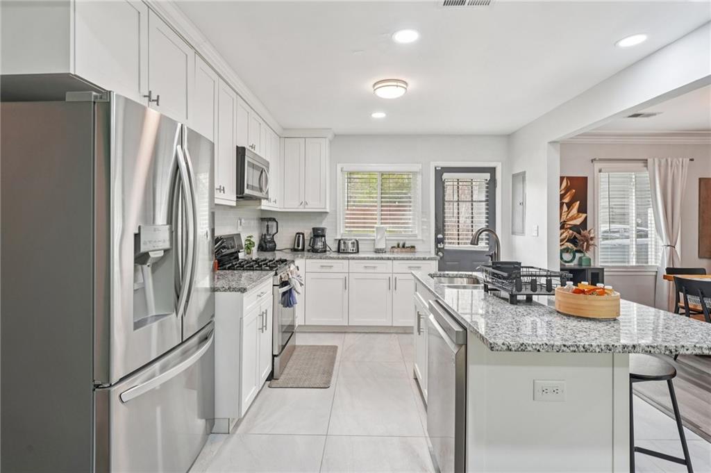 2659 Glenvalley Drive Decatur, GA 30032 - Photo 18 of 59 a kitchen with stainless steel appliances granite countertop a refrigerator a sink a stove a dining table and chairs