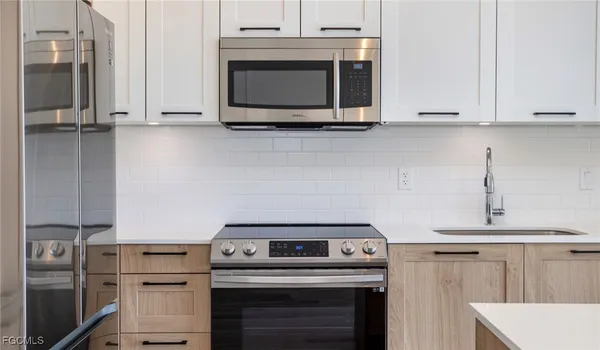 a kitchen with stainless steel appliances granite countertop white cabinets and a stove