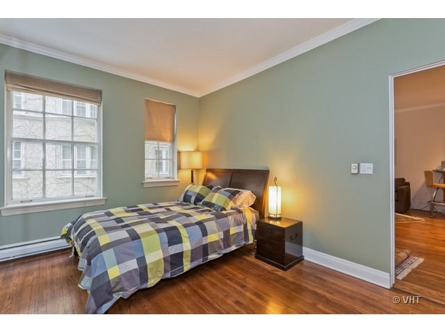 70 East Scott Street, Unit 408 Chicago, IL 60610 - Photo 6 of 9 a bedroom with a bed and wooden floor