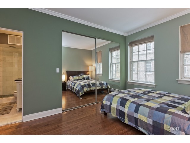 70 East Scott Street, Unit 408 Chicago, IL 60610 - Photo 8 of 9 a bedroom with a bed and a large mirror